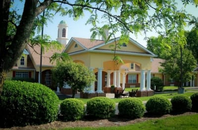 Exterior view of a senior living facility with landscaped gardens