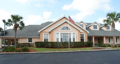 Exterior view of a senior living facility with gardens