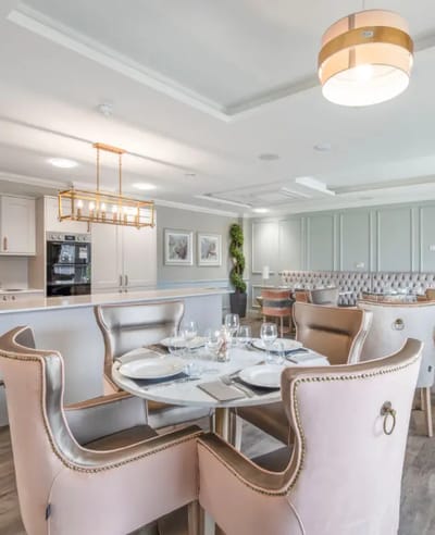 Elegant dining area with pink upholstered chairs and tableware