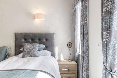 Bright private room with a bed and decorative curtains