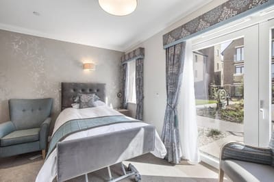 Brightly lit resident room with a view of the garden