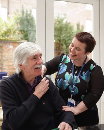 Staff member engaging with a resident in an interior setting