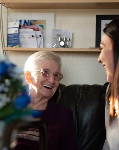Resident smiling while interacting with staff member