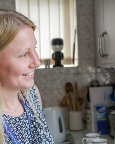 Staff member smiling in a kitchen setting