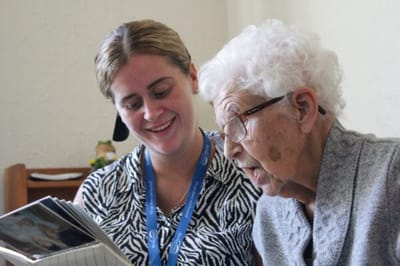 Staff member engaging with a resident over a photo album