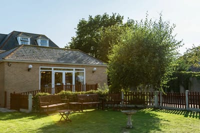 Exterior view of a facility with outdoor seating and greenery