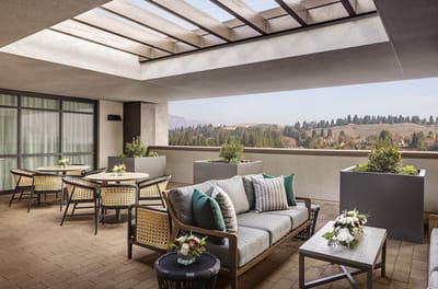 Outdoor terrace with seating and flowers overlooking nature