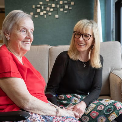 Resident and staff member sharing a moment in a cozy lounge