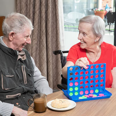 Two residents enjoying a game together with snacks