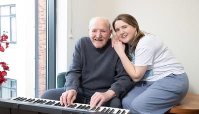 Resident and staff member enjoying music together