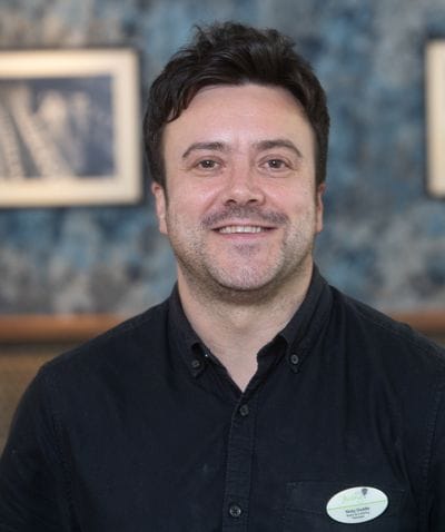 Staff member smiling in a communal area
