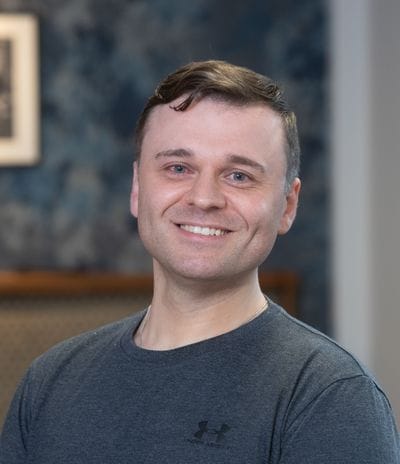 Smiling male staff member in a facility interior