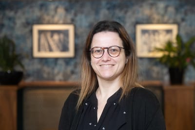 Staff member smiling in a facility interior.