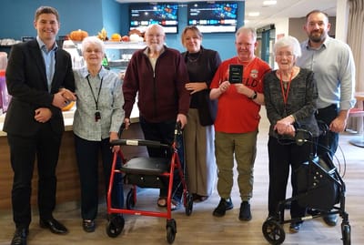 Residents and staff posing together in a common area
