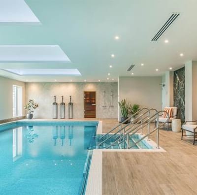 Indoor swimming pool area with lounge seating