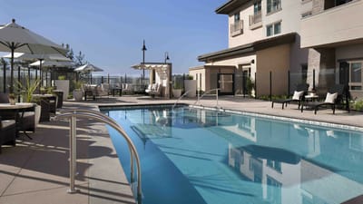 A serene outdoor pool area with lounge chairs and umbrellas