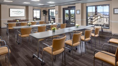 Bright activity room with tables and chairs set up
