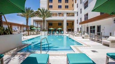 Outdoor swimming pool with lounge chairs and palm trees