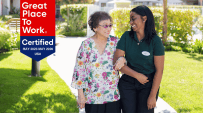 A resident and staff member enjoying a walk in the garden