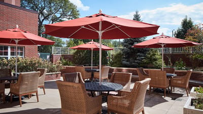 Outdoor seating area with umbrellas at a senior living facility