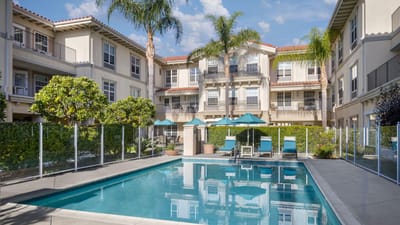 A beautiful outdoor pool area with lounge chairs and gardens