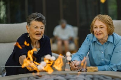 Residents enjoying marshmallows around a fire pit