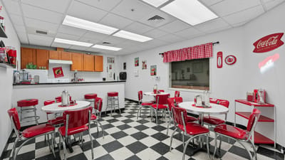 Bright dining area with red chairs and tables