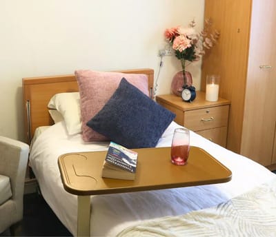 A cozy resident room with a bedside table and decor