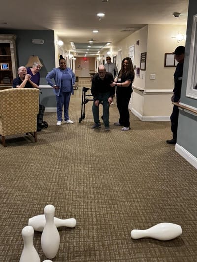 Residents and staff participating in a bowling activity