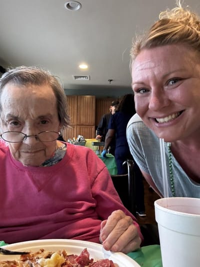 Resident enjoying a meal with staff member