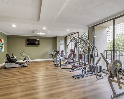 Well-equipped fitness room with exercise machines and natural light