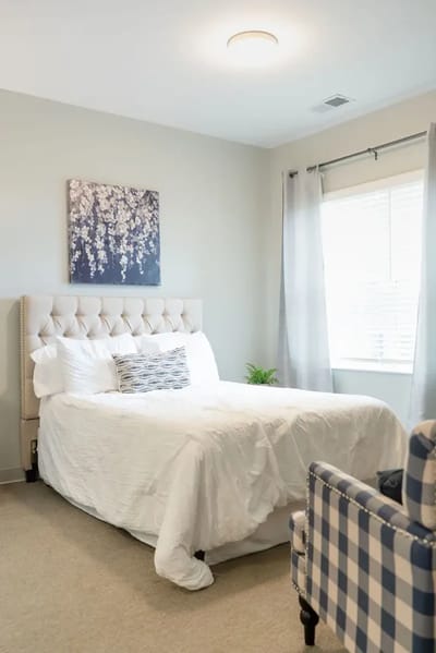 A well-decorated resident room with a bed and artwork