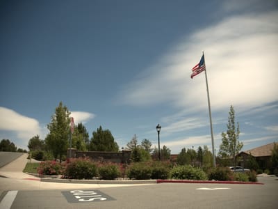 Entrance to Stone Valley Memory Care with landscaping and American flag