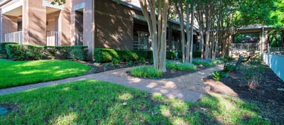 Pathway through lush landscaping beside the facility building