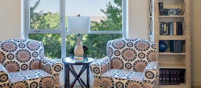 Brightly lit interior with patterned chairs and bookshelf