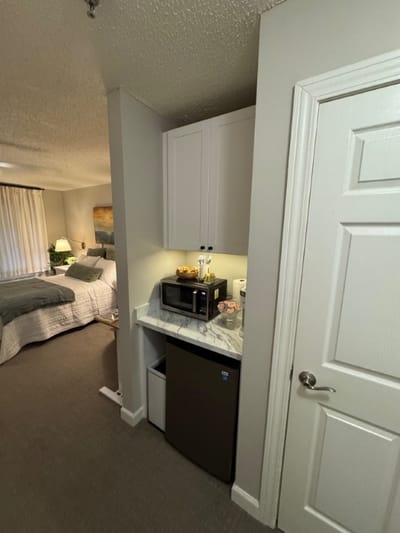 A kitchenette area with a microwave and refrigerator