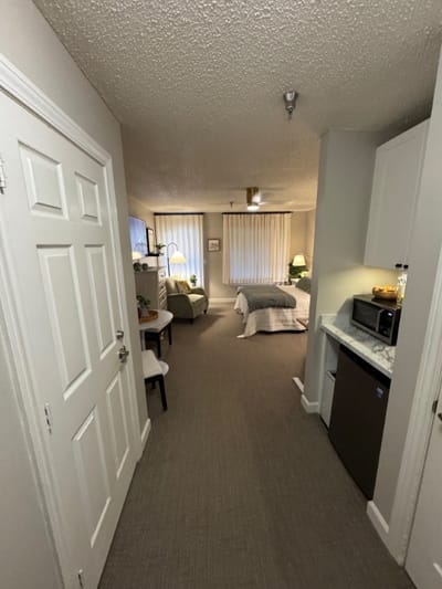 View of a cozy resident room with living area and kitchenette