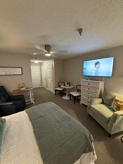 Private resident room with a television and seating area