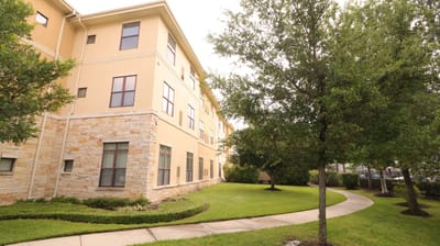 Exterior view of a senior living facility with landscaped garden