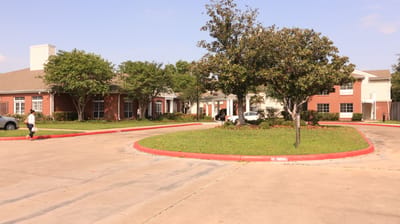 Exterior view of The Gardens of Bellaire with landscaping.