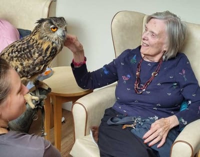 Resident interacting with an owl in a common area