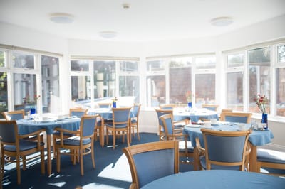 Bright dining room with blue tables and chairs.