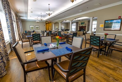 Dining area setup with tables, chairs, and decorative flowers