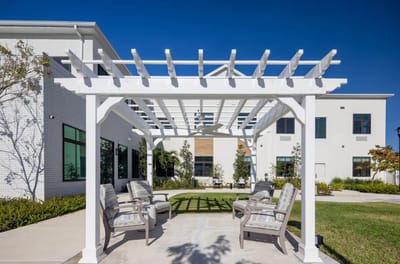Outdoor seating area with a pergola and landscaping