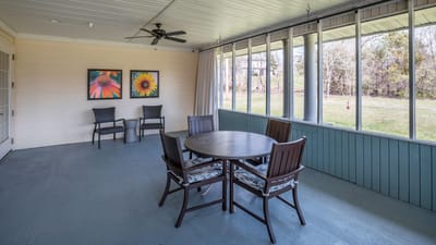 Covered outdoor seating area with flowers on the wall