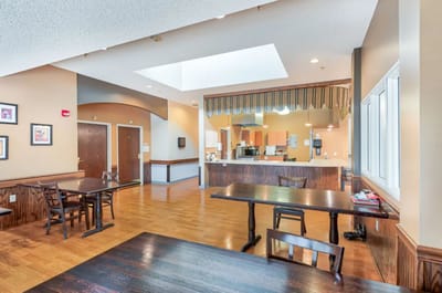 Interior view of a dining room with tables and kitchen area