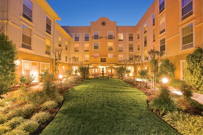 Well-lit courtyard with landscaped gardens and seating areas