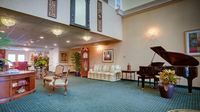 Bright lobby with a piano and comfortable seating