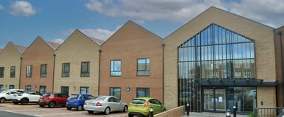 Exterior view of a senior care facility with parked cars