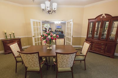 Brightly lit common area with a dining table and chairs